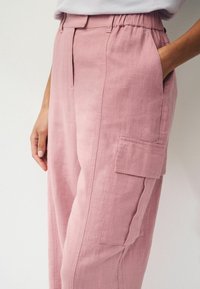 Lichtroze linnen cargobroek met een elastische tailleband, zijzakken en een voorzak. Geweven stof met een ontspannen pasvorm.