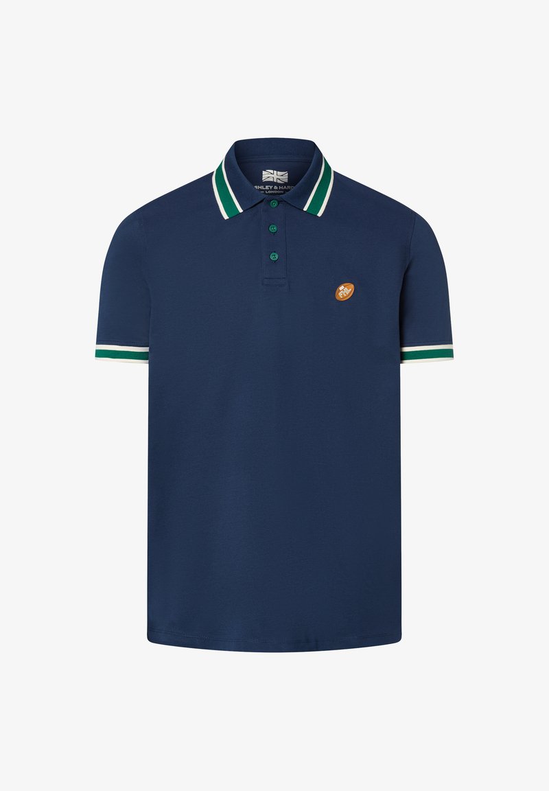 Granatowa koszulka polo z zielonym i białym paskowanym kołnierzykiem oraz mankietami, z trzema zielonymi guzikami i małą pomarańczową naszywką na klatce piersiowej.