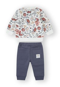 Conjunto infantil de dos piezas que incluye un sudadera blanca con estampado y gráficos coloridos, y pantalones de chándal azul marino con dos bolsillos traseros.