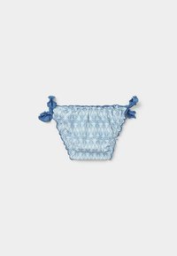 Parte inferior de bikini azul con estampado y bordes rizados, con lazos a los lados. El diseño incluye un sutil patrón de hojas en diferentes tonos de azul.