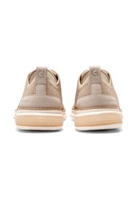 Beige Veloursleder-Sneaker mit einem Netzobermaterial, ausgestattet mit einer weißen Sohle und Logoplaketten auf der Rückseite. Abgerundetes Design mit Zuglaschen für ein einfaches Anziehen.