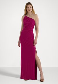 Fuksia, yksivartinen mekko, jossa on rypytetty pinta ja sivujakko. Varustettu koristeellisella yksityiskohdalla olkapäällä. Silkkinen, joustava kangas.