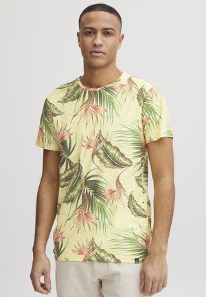 Tricou galben cu maneci scurte, prezentând un model cu frunze tropicale verzi și roz, guler rotund și țesătură moale, texturată.