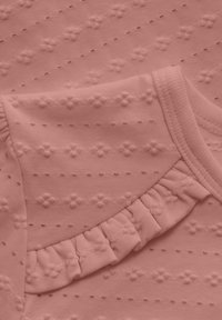 Rosa Baumwollbekleidung mit strukturierten Blumendrucken und einem frillähnlichen Akzent am Rand, mit subtilen horizontalen Streifen.