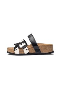 Black and white cow-print slide sandal with a cork footbed, featuring two front straps and a molded black leather strap for support.