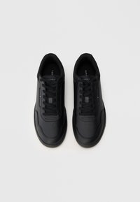 Czarne sneakersy z gładkiej skórzanej cholewki, okrągłym noskiem, perforowanymi detalami i płaskimi sznurowadłami. Zawierają logo po boku oraz wyściełaną podeszwę.