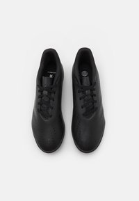Scarpe sportive nere con un upper liscio e strutturato, caratterizzate da dettagli perforati, lacci piatti e punta rotonda.
