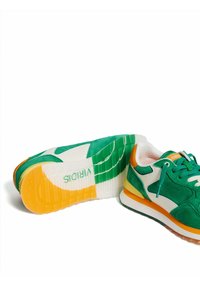 Baskets en suède vert avec des accents orange, des détails en cuir blanc, une semelle texturée et une semelle extérieure multicolore portant la marque "WIRIDIS".