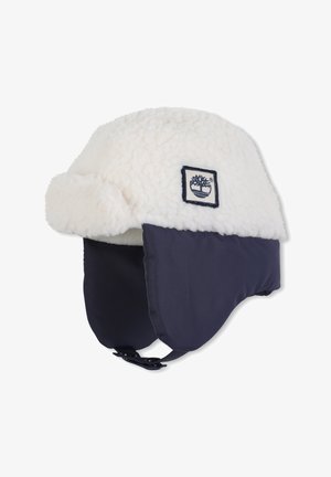 Wintermuts met een fleecevoering, een witte buitenlaag, een marineblauwe zijkant, een kinband en een logo-patch. Zachte textuur met een ronde vorm.