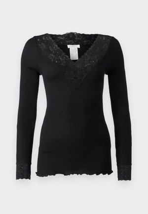 Czarny longsleeve z prążkowanej tkaniny, z dekoltem z koronką w kwiatowy wzór i koronkowymi akcentami przy mankietach. Falbaniasty detal u dołu.