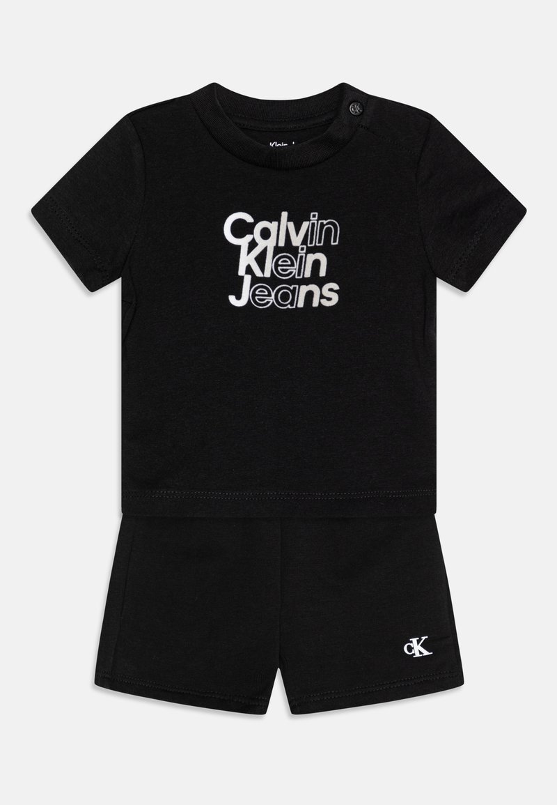 Conjunto de algodón negro que incluye una camiseta de manga corta con el logo blanco "Calvin Klein Jeans" y pantalones cortos a juego. Tejido suave con un diseño sencillo.
