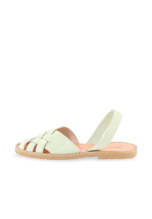Lichtgroene suède platte sandaal met gevlochten voorbanden, open teen en een achterriem op een tankleurige rubberen zool.