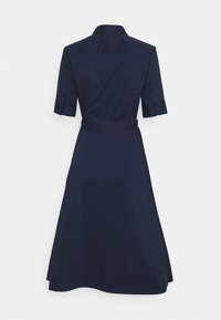 Mörk marinblå skjortklänning med korta ärmar, en figurnära midja och en utsvängd kjol, utställd mot en enfärgad vit bakgrund.