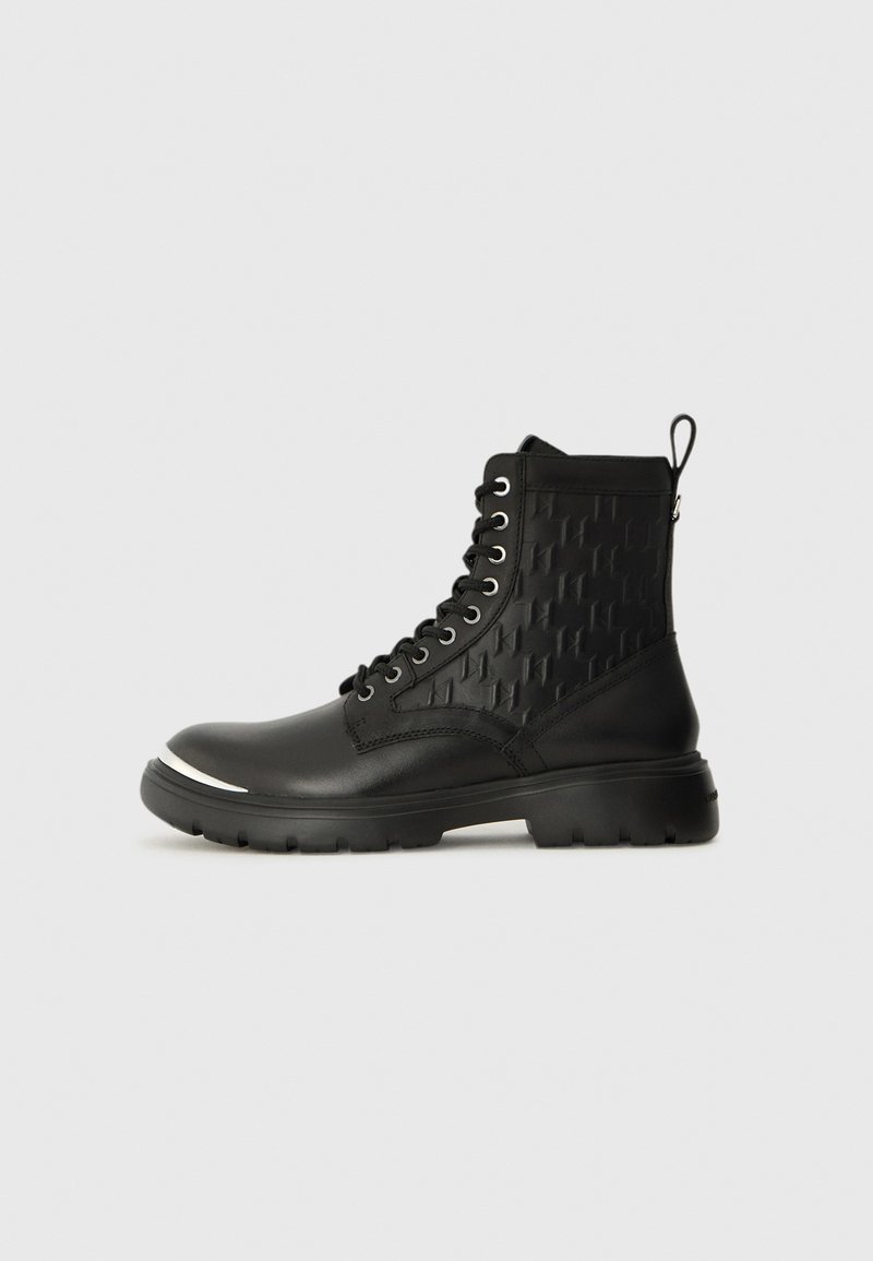 Black lace-up ankle boots with a textured side panel, a rounded toe, and a durable sole featuring a silver accent on the front.