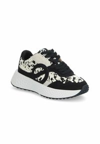 Baskets noir et blanc avec un design moucheté, en matériaux de daim et de textile lisse, avec une languette rembourrée et une semelle blanche rembourrée.