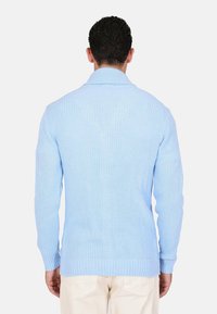 Cardigan lavorato a maglia di un blu chiaro con colletto a coste, maniche lunghe e un motivo testurizzato. Tessuto morbido con un design aderente, senza accenti visibili.