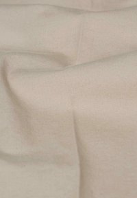 Hellbeige Stoff mit glatter Textur, der einen subtilen Glanz und feine diagonale Rippungen aufweist, geeignet für Kleidung oder Polsterung.