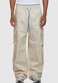 Beige cargo bukser med præget logo mønster, snøring med blå detaljer og flere sidelommer.