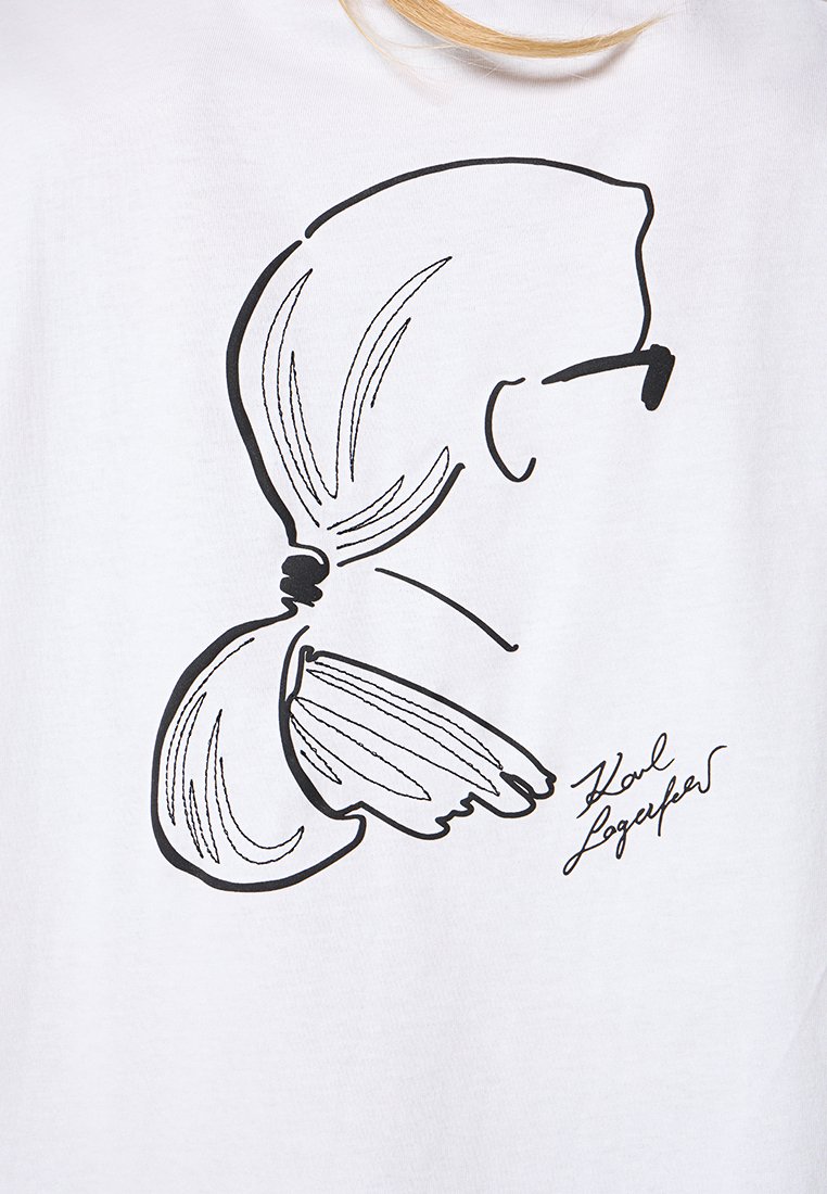 Weißes T-Shirt mit einer schwarzen Umrissillustration eines Pferdeschwanzfrisur und einer Brille, begleitet von der Unterschrift "Karl Lagerfeld."
