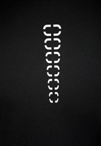 Tessuto nero con un motivo verticale di forme geometriche bianche che ricordano parentesi, creando un contrasto con la trama del tessuto.