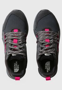 Scarpe sportive nere con tomaia in mesh e materiale sintetico. Presentano dettagli in rosa, lacci grigi e una suola in gomma testurizzata. Marchio visibile all'interno.
