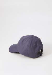Purple cotton cap with a curved brim, six vents, and an adjustable strap at the back. The texture appears smooth and durable.