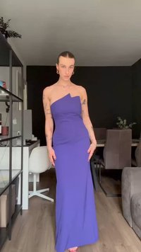 Vestido maxi roxo, justo ao corpo, com um ombro só, textura suave, design até ao chão e um drapeado subtil na cintura.