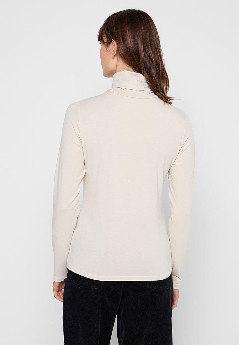 Beige Langarm-Turtleneck-Oberteil aus weichem, elastischem Stoff, mit einer taillierten Silhouette und einem subtilen Rollkragen.