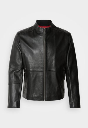 Črna usnjena jakna z dvignjenim ovratnikom, sprednjim zadrgo in dvema stranskima žepoma z zadrgo. Gladka tekstura z šiviljskimi detajli.