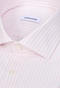 Chemise habillée rayée rose clair et blanc avec col pointu et boutons blancs, étiquette de marque "seidensticker" à l'intérieur du col.