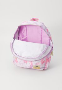 Öppen rosa och vit blommig ryggsäck med en frametikett "MILKY KISS X" på en vit bakgrund.