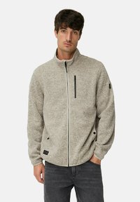 Fleecejacke in hellgrau mit Reißverschluss, hohem Kragen, Seitentaschen und einer kleinen Brusttasche. Ausgestattet mit strukturiertem Stoff und dezentem Branding.
