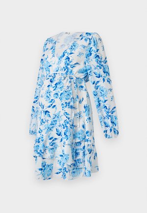 Bloemen wikkeljurk in het wit met blauwe bloemen. Kenmerkt lange poffende mouwen, een strik in de taille, en gelaagde ruches aan de zoom.