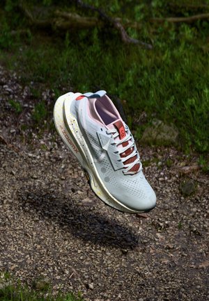 Zapatilla de correr de color gris claro con parte superior de malla, acentos en rosa y una entresuela salpicada de colores vibrantes. Presenta un diseño perforado y una suela acolchada.