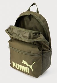 Πράσινο υφασμάτινο σακίδιο με μπροστινή τσέπη με φερμουάρ, δίχτυ σε πλαϊνή τσέπη και εμφανές λευκό λογότυπο Puma στο μπροστινό μέρος. Εσωτερική επένδυση.