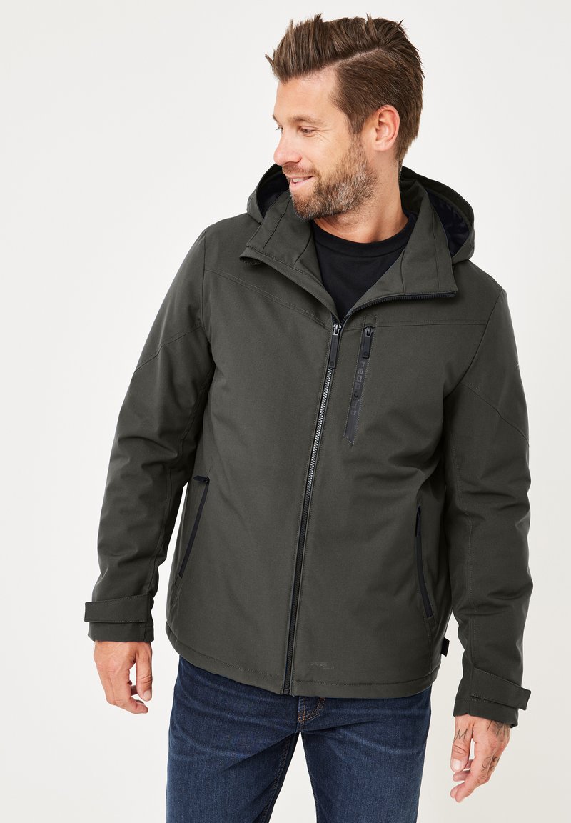 Dunkelgrüne wasserfeste Jacke mit Kapuze, ausgestattet mit einem Reißverschluss vorne und seitlichen Taschen, verstellbaren Bündchen und einer glatten Textur.