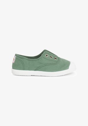 Zelená plátěná obuv typu slip-on s bílou gumovou podešví a špičkou. Obsahuje dva kovové očky na boku pro větrání.