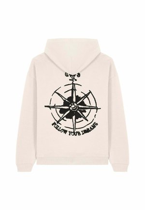 Felpa con cappuccio di un leggero beige, caratterizzata da un design a forma di bussola nera e la scritta "SEGUITI I TUOI SOGNI" sopra. Tessuto morbido.