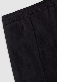 Pantaloni in corduroy neri con vita elasticizzata, caratterizzati da sottili linee verticali, texture liscia e vestibilità ampia.