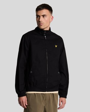 Black bomber jacket with a stand collar, front zip closure, two side pockets, elastic cuffs, and a small yellow logo on the chest.