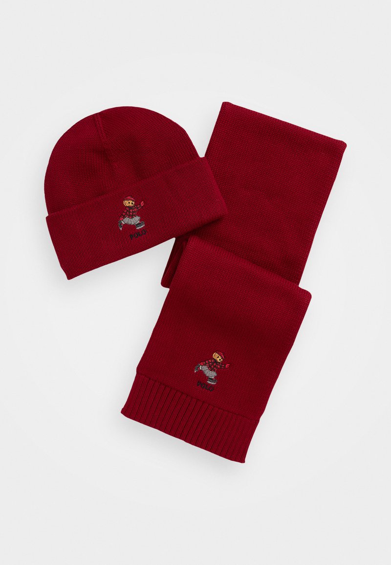 Conjunto de gorro de malha vermelha e lenço com textura canelada. Cada peça possui um design de personagem bordado com a palavra "Polo."