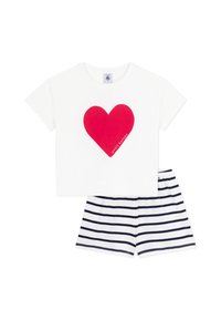 T-shirt blanc à manches courtes avec un grand motif de cœur rouge et le texte "petit bateau", associé à un short rayé bleu marine et blanc.