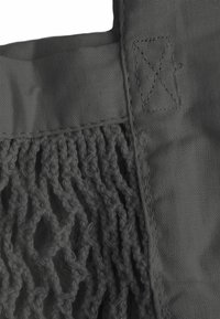 Szara torba wielokrotnego użytku, z górną częścią wykonaną z jednolitego materiału i dolną częścią z teksturowanej siateczki, z mocnymi szwami i wyciętymi uchwytami ułatwiającymi noszenie.