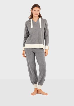 Grijze gebreide loungewear set met een capuchon bovenstuk, voorzien van crèmekleurige ribgebreide manchetten en zoom, en bijpassende drawstring broek met ribgebreide enkels.