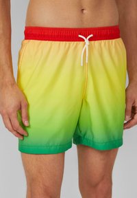 Zwemshorts met een elastische rode tailleband, witte trekkoord en een gradientontwerp van geel naar groen. Glad materiaal en een lengte tot halverwege de dij.
