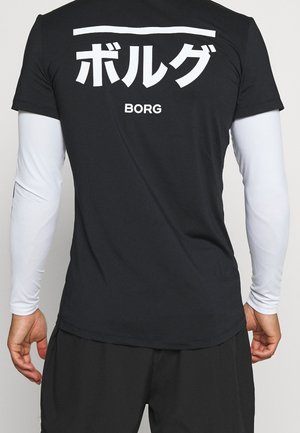 Person iført en sort kortærmet skjorte over en hvid langærmet top med hvide japanske tegn og "BORG" tekst på ryggen.