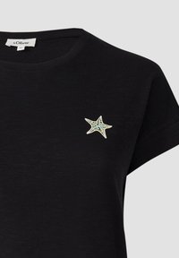 Zwarte t-shirt met korte mouwen, voorzien van een multicolor geborduurde ster op de linkerkant van de borst. Zacht materiaal met een klassieke pasvorm.