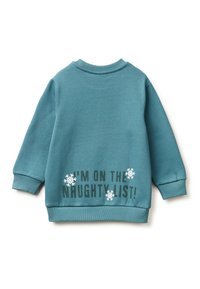 Tyrkysová mikina s dlouhými rukávy, žebrovanými manžetami a zaobleným výstřihem. Na zadní straně je nápis „Jsem na seznamu zlobivých!“ s vločkami sněhu.