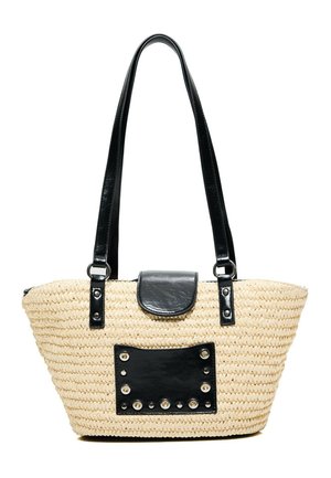 Beige gewebte Strohtasche mit langen schwarzen Griffen, einem schwarzen Lederklappverschluss und einem schwarzen, mit Nieten besetzten rechteckigen Patch vorne.