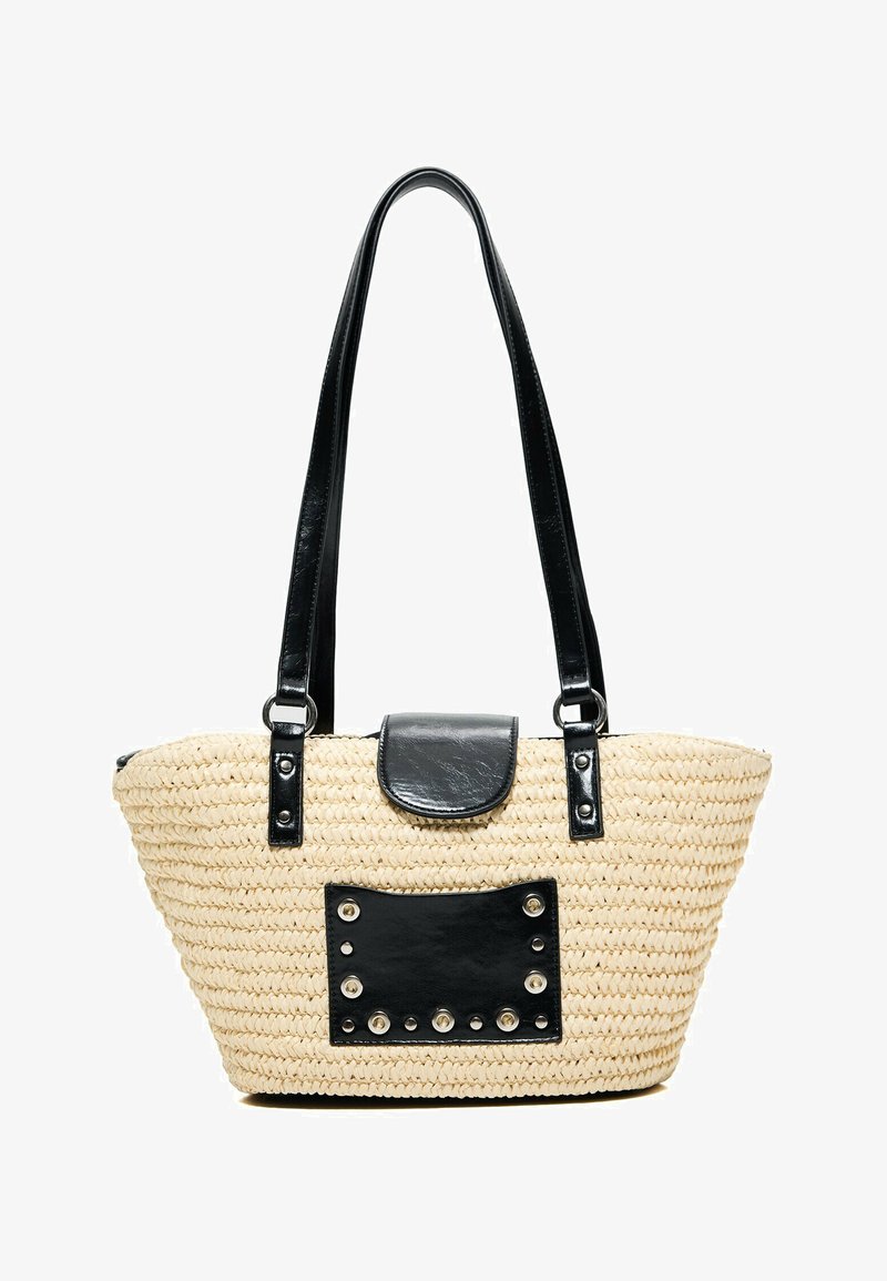 Sac cabas en paille tissée beige avec de longues poignées noires, une fermeture à rabat en cuir noir et un patch rectangulaire noir clouté à l'avant.
